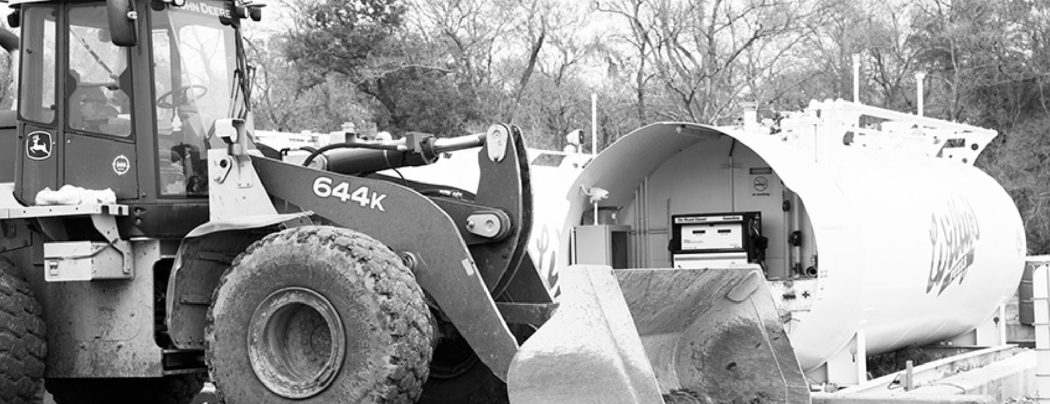Heavy equipment operating beside a Willy's Fuels tank
